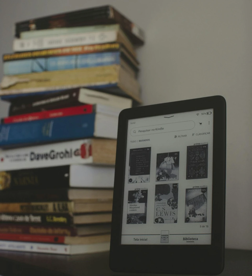 a tablet sitting on top of a table next to a pile of books